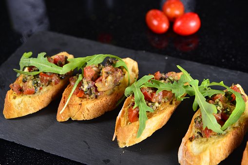 Tapas, Weißbrotscheiben mit Tomaten und Rucola