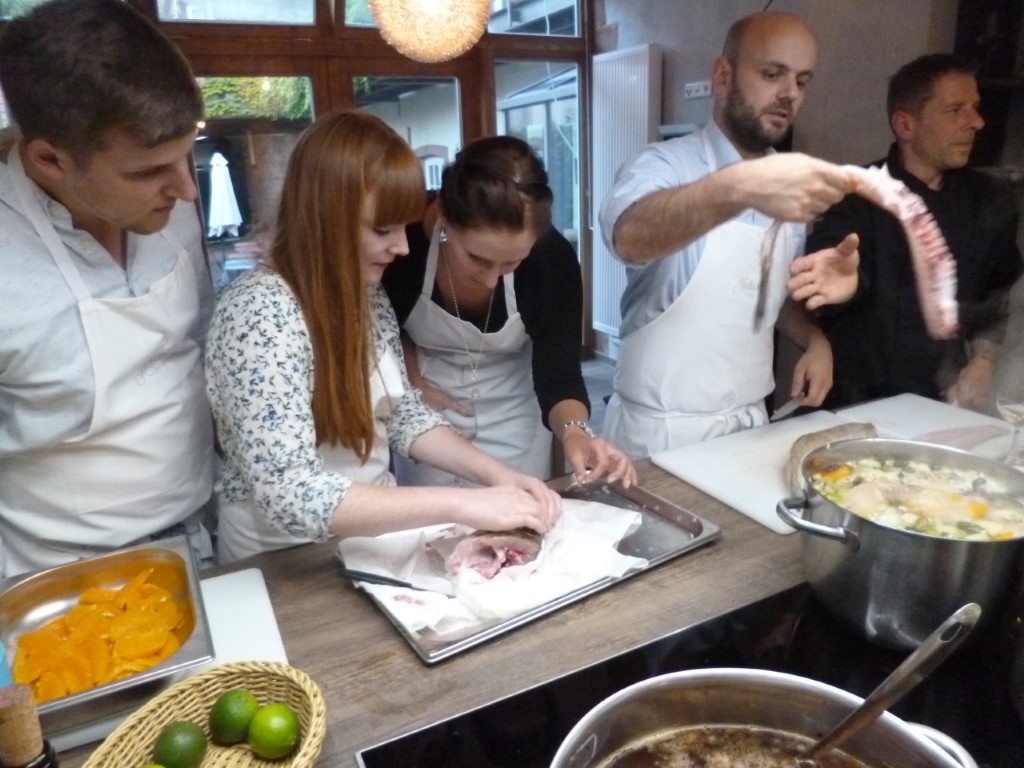 Kochkurs-Teilnehmer beim Fischputzen