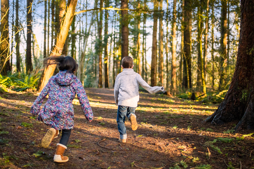 Zwei Kinder rennen durch den Wald